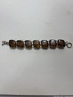 Full view of the vintage Mexican amber bracelet laid flat against a white background, showing seven square amber stones set in silver.