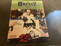 Full view of signed Cal O'Reilly hockey photo with bold 13th season text and Xfinity branding