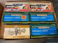 Photo showing 2 boxes of Tuff Stuff Entry Locks and 4 boxes of Tuff Stuff Privacy Locks in a cardboard box
