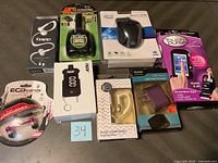 Top view of earphones, computer mouse, USB charger, digital scale, and other electronics arranged on a surface.