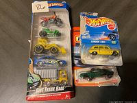 Photo of Hot Wheels 5-pack and two other packaged diecast cars including a London Taxi and a Matchbox classic car