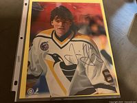 Signed photo of Jaromir Jagr wearing a white Pittsburgh Penguins jersey with his autograph signed in blue ink.