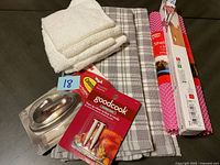 Photo showing the set of kitchen towels, plaid towel, pink baking mat, aluminum foil box, stainless steel butter dish, and GoodCook pop-up timer in packaging.