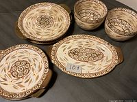 Photo of 5 ceramic serving pieces showing two round dishes with handles, one oval dish with handles, and two round bowls, all with brown and beige floral pattern.
