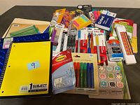 Overview of the variety of new office and school supplies including notebooks, writing instruments, adhesives, sticky notes, and organizational items