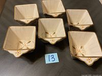 Set of six square ceramic bowls with floral patterns, viewed from above showing interior