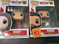Two boxed Funko POP! vinyl figurines from Shazam! movies, Mary #1280 and Pedro #1282, shown front and side view.