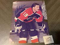 Signed photo of a Philadelphia Flyers hockey player with number 19 in red, black, and white jersey, holding a hockey stick on ice.