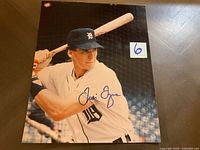 Signed photo of Travis Fryman in Detroit Tigers uniform posed in batting stance holding a wooden bat with clear blue ink autograph across chest
