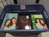 Top view of the bin showing multiple DVD cases including multiple volumes of The Gilmore Girls and The Strain Complete First Season.