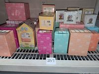 Various boxed Precious Moments figurines displayed on a shelf, showing multiple colors and sizes of boxes.