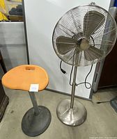Photo showing both the metal oscillating fan and the Focal Mobis stool side by side