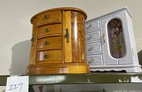 Both jewelry boxes side by side on a shelf, showing the medium brown box in front and the white box behind it