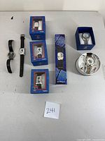 All 7 watches arranged on a white surface with boxes where included, showing the collection together