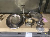 Wide view showing all items in lot including two candlestick holders, two small bowls, serving dish, small bowl, salt spoons, and pewter holder