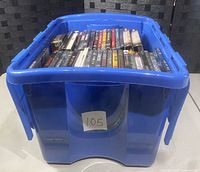 Blue storage bin filled with used horror DVDs, showing quantity and container type.