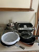 Kettle, frying pan with lid, stainless steel saucepans stacked, plastic strainer, OptiGrill appliance