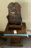 Full frontal view of wooden colonial nautical table clock with battery-operated mechanism, Roman numeral face, and eagle emblem.