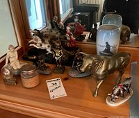 Overview of lot including vase, multiple figurines both human and animal shaped, and a bronze bull