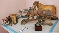 Full view of the six wild animal figurines, including tigers, lions and a cougar bust.