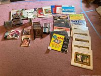 Overview of collection showing stacks of CDs, vinyl records, and audio cassettes spread on floor.