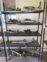 Shelf display of ten model airplanes including British WWII fighters, American bombers, and a commercial jetliner.