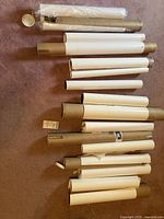 Multiple rolled prints in cardboard tubes and some wrapped, laid out on carpet floor.