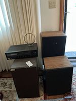 Yamaha stereo receiver on top of one KLH speaker with two other KLH speakers nearby