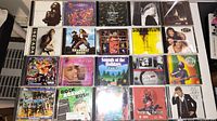 Photo showing 20 various music CDs arranged in a grid with some visible titles and artists.