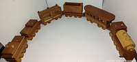 Full view of the wooden toy train set, showing six connected cars including locomotive and boxcars with natural wood finish.