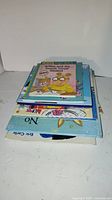Stack of 8 kids books with visible titles including Arthur book on top