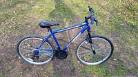Side view of blue Pacific 26-inch mountain bike showing frame, tires, and pedals