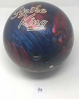 Front side showing Strike King logo and finger holes on red and blue swirl bowling ball
