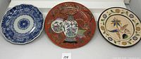 Front view of three decorative plates showing varied artistic designs and colors.
