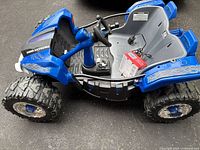 Front-right side view of ride-on, battery and charger visible inside seat area