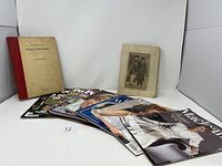 Collection of royal family themed scrapbook, magazines, and book arranged on a white surface