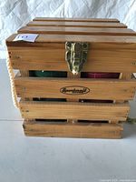 Front view of wooden slatted crate-style bocce ball case with metal latch showing the Sportsraft brand plate and closed latch.