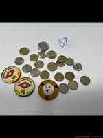 Top view of all casino tokens and chips showing variety in materials and denominations including metal coins and colored casino chips