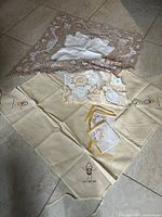 Full view of all linens including crochet doilies, table cloth, and napkins laid out on floor.