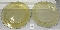 Two vintage yellow amber glass serving plates with detailed Federal Glass Patrician/Spoke pattern and scalloped edges, placed side by side on white background.