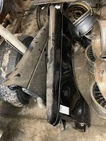 Pair of 1980s GM S10 front fenders stacked, showing overall shape and condition including dust and surface wear.