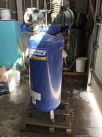 Overall front view of blue upright compressor on wooden pallet