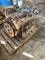 Top-down view of the cast iron engine with aluminum intake and four-barrel carburetor, chain for hoist attached