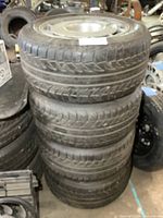 Stack of four tires mounted on Corvette wheels showing tread condition and overall stack