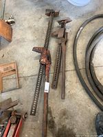 Both farm jacks side by side on concrete floor showing size difference and condition.