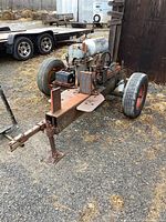 Front-side view showing tow hitch, wheels, engine housing and hydraulic beam