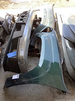 Top-down view showing green and silver fenders side by side with bumper