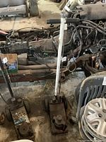 Full side view of the heavy duty pneumatic shop jack beside auto parts and tires in workshop.