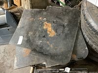 Pair of large heavy truck mud flaps stacked, showing significant rust stains and wear marks, measured approximately 24x30 inches