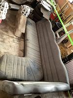 L-shaped vinyl limousine seat, dusty and worn, showing overall structure and upholstery condition.